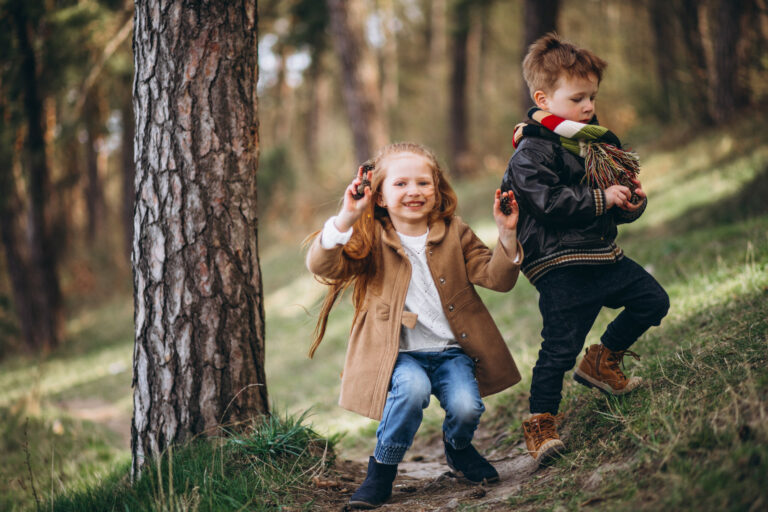 Girl with her little brother together in forest